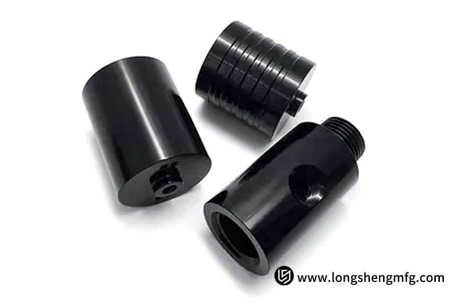 Three black anodized automotive components with glossy finish by LS Manufacturing